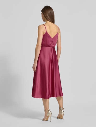 Frauenmodel trägt Cocktailkleid mit Wasserfall-Ausschnitt von Jake*s Cocktail in Satin, tailliert, knielang, Spaghettiträger, Rückansicht.