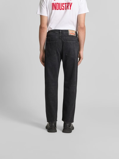 Männermodel trägt Loose Fit Jeans mit Lyocell-Anteil von Diesel in Schwarz, 5-Pocket-Design, Baumwoll-Lyocell-Mix, Ganzkörperansicht Rückansicht.