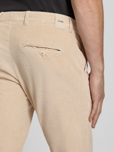 Männermodel trägt Modern Fit Cordhose aus Baumwoll-Mix Modell 'Fabio' von Brax in Beige mit feiner Cordstruktur, Nahaufnahme Rückansicht. Herren Cordhose von Brax.