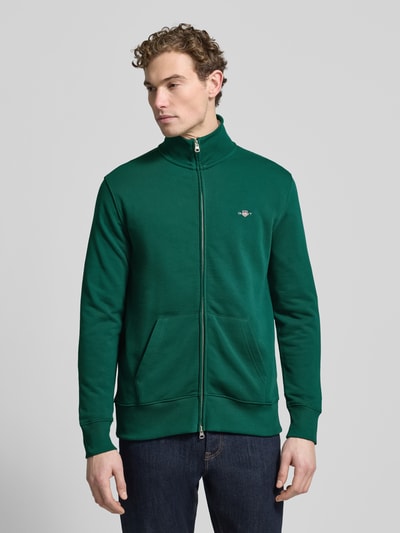 Männermodel trägt grüne Sweatjacke mit Label-Stitching von Gant aus Baumwoll-Mix, Regular Fit, Stehkragen, Vorderansicht Oberkörper.