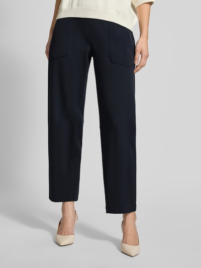 Frauenmodel trägt Jogpants mit elastischem Bund Modell 'OCEAN' von Cambio, dunkelblauer Farbton, Material-Mix mit Stretch-Anteil, Regular-Fit, Nahaufnahme Vorderansicht.
