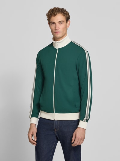 Männermodel trägt Slim Fit Sweatjacke mit Strukturmuster von MCNEAL in Grün mit weißen Details, elastischer Material-Mix, Ganzkörperansicht von vorne.