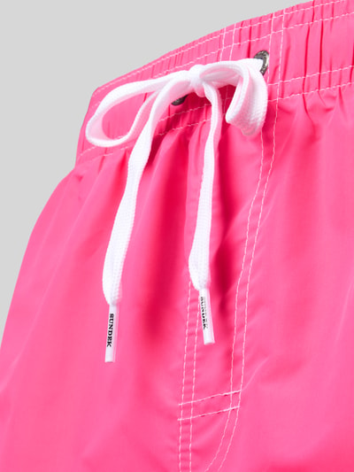 Produktfoto, leuchtend pinke Badehose mit elastischem Bund und Tunnelzug, Modell 'UNI SHORTS NEON' von Sundek, glatte Textur