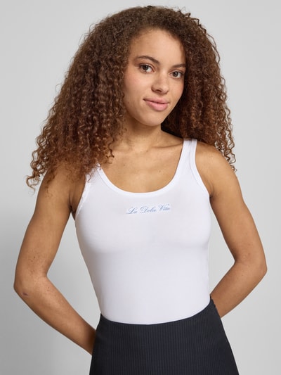 Frauenmodel trägt Tanktop mit Rundhalsausschnitt und Stickerei von REVIEW, Damen, Weiß, Baumwoll-Elasthan-Mix, Slim-Fit, Nahaufnahme Oberkörper. Rückenlänge bei Größe S 36 cm.