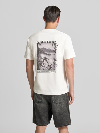 Männermodel trägt weißes Relaxed Fit T-Shirt aus reiner Baumwolle von Marc O'Polo mit schwarzem Print, Ganzkörperansicht Rückansicht, Herren T-Shirt