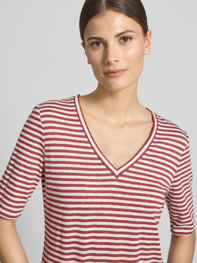 Vrouwenmodel draagt Regular Fit T-shirt uit linnenmix model 'OPZIONE' van Weekend Max Mara in meerkleurige look, gestreept motief, logoprint, V-hals, korte mouw, fijngebreide materiaalverwerking, Nahaufnahme bovenlichaam.