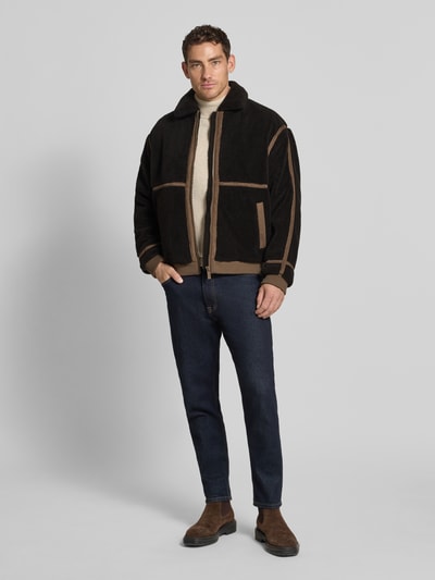 Männermodel trägt Teddy-Jacke mit Reißverschluss von MCNEAL, Regular Fit, schwarz-braun, Umlegekragen, Eingrifftaschen, Ganzkörperansicht von vorne.