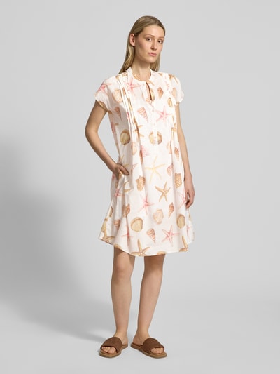 Frauenmodel trägt Knielanges Kleid mit Tunikakragen von Emily Van den Bergh, Reine Baumwolle, Taillierter Schnitt, Biesen, Muschelprint, Ganzkörperansicht von vorne.