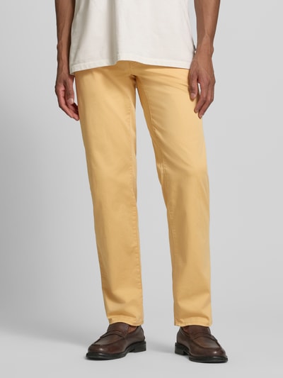 Männermodel trägt Slim Fit Stoffhose mit Lyocell-Anteil Modell 'Cadiz' von BRAX in Gelb, Baumwoll-Lyocell-Mix, 5-Pocket-Design, Nahaufnahme Unterkörper.