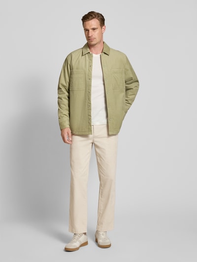 Mężczyzna nosi Straight Fit Chino aus Baumwoll-Mix model 'Chino_Keyes_DS' od BOSS Orange, beżowe, gładkie, Ganzkörperansicht von vorne.