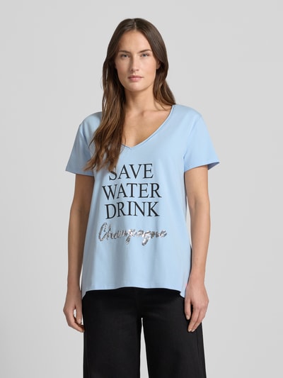 Frauenmodel trägt T-Shirt mit Statement-Print von miss goodlife in Hellblau, locker geschnitten aus Baumwoll-Elasthan-Mix, V-Ausschnitt, Ganzkörperansicht von vorne.