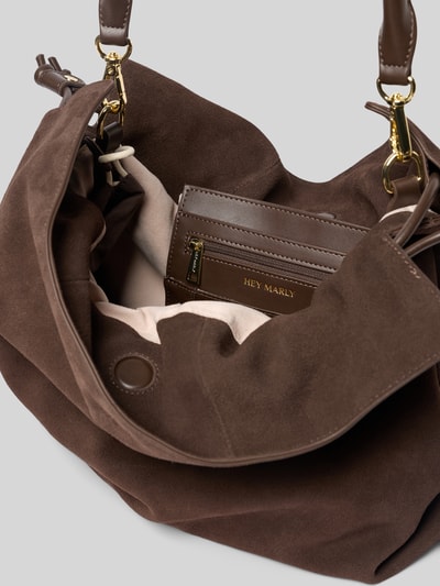 Produktfoto, braune Handtasche in Suede-Optik Modell 'Cool Companion' von Hey Marly mit Magnetverschluss und abnehmbarem Schulterriemen, Innenfach mit Reißverschluss, Maße 40x34x15 cm, detailreiche Nahaufnahme der texturierten Oberfläche und des Innenlebens