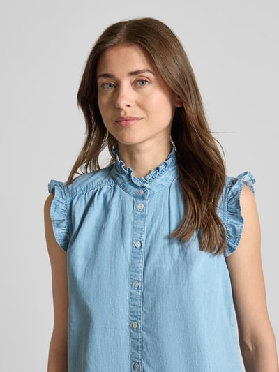 Vrouwenmodel draagt Blusentop in Denim-Optik mit Rüschen van Christian Berg Woman, mix van katoen en lyocell, regular fit, denimlook, opstaande kraag, ruches, ruglengte maat 36: 57 cm, mouwlengte maat 36: 50 cm, lichte blauwe kleur, zichtbare knopen, textuur met subtiele structuur, nahaufnahme oberkörper.