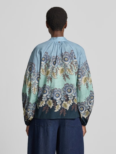 Vrouwenmodel draagt Relaxed Fit Bluse aus reiner Baumwolle van Rich & Royal met opstaande kraag, all-over bloemenprint, met lange mouwen, knoopsluiting, puur katoen. Ruglengte maat 36: 59 cm, mouwlengte maat 36: 66 cm. Ganzkörperansicht Rückansicht.