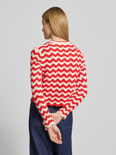 Frauenmodel trägt Strickjacke im Allover-Look mit Rundhalsausschnitt von Christian Berg Woman in Rot und Creme aus Reine Baumwolle, Regular-Fit, Rückenlänge bei Größe S 53 cm, Ärmellänge 66 cm, Knopfleiste, Ganzkörperansicht Rückansicht.