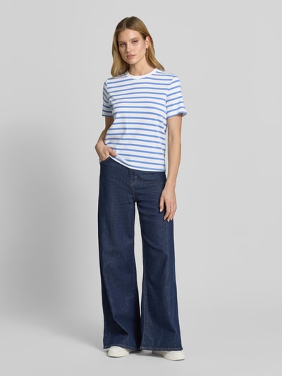 Modelka nosi T-Shirt im Allover-Look mit Rundhalsausschnitt von comma, bawełna z domieszką elastanu, krój regular fit, paski niebiesko-białe, widok całej sylwetki z przodu.