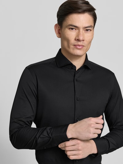 Männermodel trägt Slim Fit Businesshemd aus reiner Baumwolle Modell 'H-HANK-SP' von BOSS, Optik:Allover-Muster, Nahaufnahme Oberkörper.