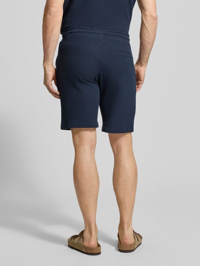 Männermodel trägt Sweatshorts mit elastischem Bund von MCNEAL aus Elastischer-Material-Mix, Strukturmuster, Gerade Passform, Ganzkörperansicht Rückansicht.