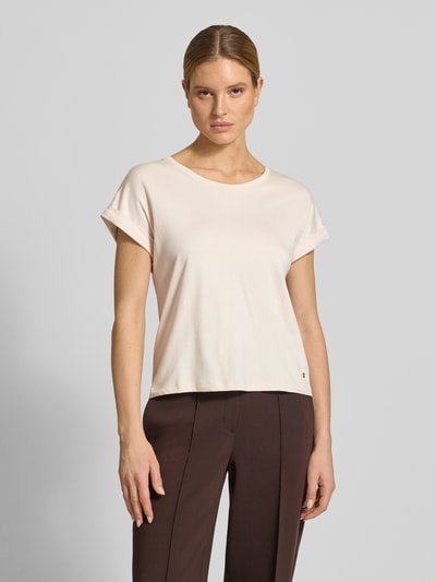 Frauenmodel trägt T-Shirt mit fixiertem Ärmelaufschlag von monari in Beige, reine Baumwolle, gerader Schnitt, Nahaufnahme Oberkörper.
