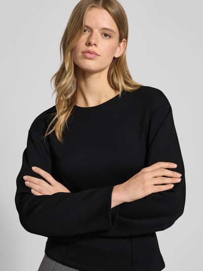 Frauenmodel trägt Shaped Fit Langarmshirt mit Viskose-Anteil Modell 'TOC' von Only in Schwarz, Kimonoärmel, Nahaufnahme Oberkörper.