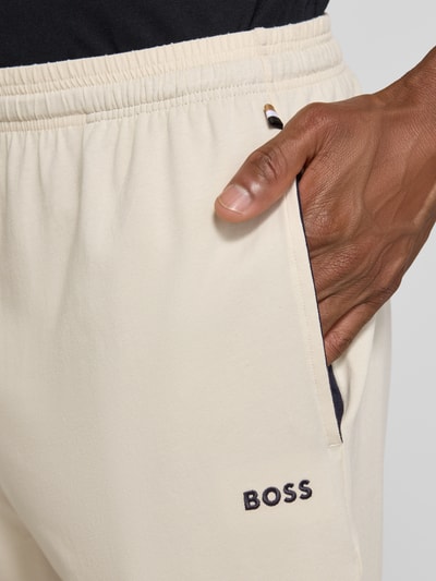 Männermodel trägt Regular Fit Sweatshorts aus Baumwoll-Mix Modell 'MIX&MATCH' von BOSS, beige mit dunklem Taschenfutter, Nahaufnahme Oberkörper, Herren Sweatshorts von BOSS.