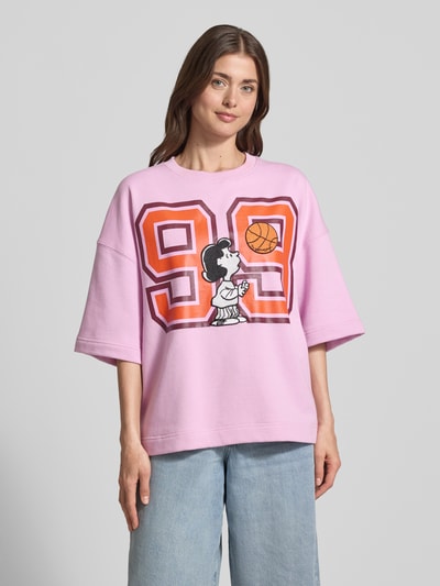 Frauenmodel trägt Loose Fit Sweatshirt mit Snoopy®-Print Modell 'JUMPI EMBO' von Essentiel Antwerp in Rosa mit 3/4-Arm und Motiv-Print, Baumwoll-Mix, Ganzkörperansicht von vorne.