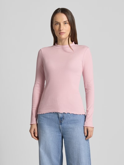 Frauenmodel trägt Slim Fit Langarmshirt aus Baumwoll-Mix von Tom Tailor Denim in Rosa, feine Rippstruktur, Frill-Abschlüsse, hochgeschlossen, unifarben, Label Patch, Ganzkörperansicht von vorne.