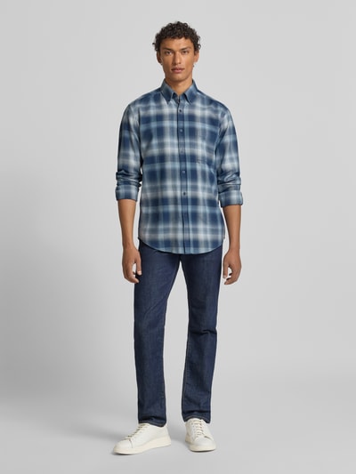 Mężczyzna nosi Regular Fit Freizeithemd aus reiner Baumwolle Modell 'RICKERT_M' von BOSS Orange, wzór w kratkę, odcienie niebieskiego, kołnierzyk typu button down, listwa guzikowa, długi rękaw z mankietem sportowym, kieszeń na piersi, zaokrąglone wykończenie, bawełna, całkowity widok z przodu.