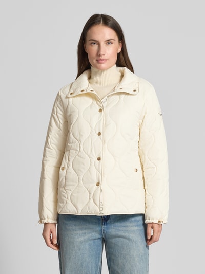 Modelka kobieta ma na sobie Regular Fit Steppjacke mit gefüttertem Stehkragen od Christian Berg Woman Selection, kremowy kolor, przeszycia, kieszenie, pełna listwa guzikowa, krój regular fit, długość tyłu 62 cm, szerokość ramion 41 cm, szerokość w rozmiarze 52 cm, długość rękawa 62 cm, widok całej sylwetki z przodu