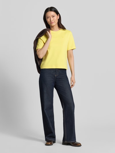 Vrouwenmodel draagt T-shirt met Label-Stitching van Oui, puur katoen, regular fit, ronde hals, ruglengte maat 36: 54 cm. Volledige lichaamsopname van voren.