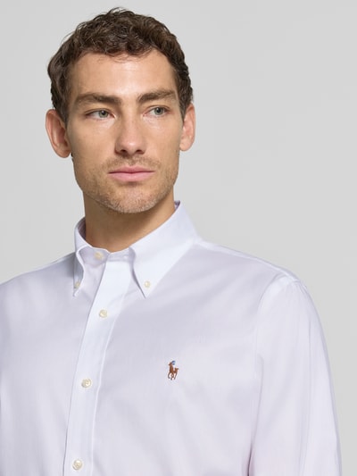 Männermodel trägt Regular Fit Businesshemd aus reiner Baumwolle von Polo Ralph Lauren in Weiß mit Knöpfen, Nahaufnahme Oberkörper.