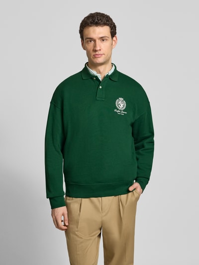 Männermodel trägt Regular Fit Sweatshirt aus Baumwoll-Mix von Polo Ralph Lauren in Dunkelgrün, unifarben mit Polokragen und Label Print, Ganzkörperansicht von vorne.