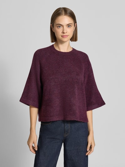Frauenmodel trägt Regular Fit Pullover mit 3/4-Ärmeln Modell 'SIMONI' von ONLY in Dunkellila, lockere Passform, Damen Pullover, Ganzkörperansicht von vorne.