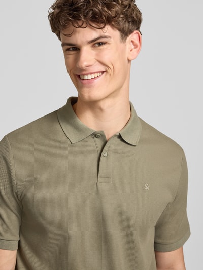Männermodel trägt Regular Fit Poloshirt mit Strukturmuster Modell 'AUSTIN' von Jack & Jones, Knopfleiste, Baumwoll-Mix, Nahaufnahme Oberkörper.