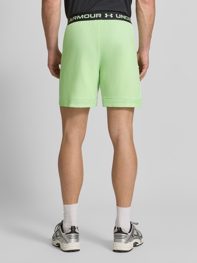 Männermodel trägt Shorts mit elastischem Bund und Logo van Under Armour in lichtgroen met steekzakken, regular fit, ganzkörperansicht rückansicht.