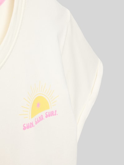 Meisje draagt T-shirt met print en ronde hals van DANAMADE, mix van katoen en elastaan, relaxed fit, omslag aan de mouwen, detailopname.