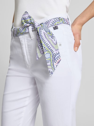 Frauenmodel trägt Hose mit Bindegürtel von Marc Cain im Baumwoll-Lyocell-Mix und Regular-Fit mit Eingrifftaschen, Nahaufnahme Oberkörper.