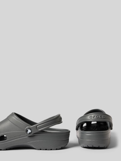 Produktfoto, Clogs mit Label-Detail von Crocs, szary kolor, zaokrąglony nosek, wsuwana forma, regulowany pasek, wysokość obcasa 5 cm w rozmiarze 43/44