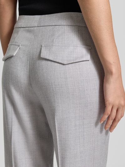 Frauenmodel trägt Stoffhose aus Schurwolle-Mix mit Bügelfalte von windsor in Hellgrau, glatte Struktur, angedeutete Gesäßleistentaschen, Nahaufnahme Rückansicht.