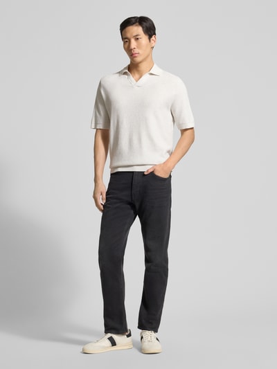 Männermodel trägt Regular Fit Poloshirt aus reiner Baumwolle von Tom Tailor in Strickoptik mit V-Ausschnitt, Ganzkörperansicht von vorne.
