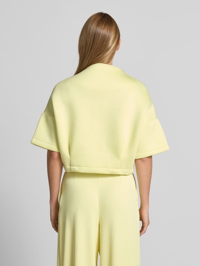 Frauenmodel trägt Jacke mit 1/2-Arm und Reißverschlusstaschen von Rinascimento in hellem Gelb, Viskose-Mix, gerader Schnitt, Rückansicht.