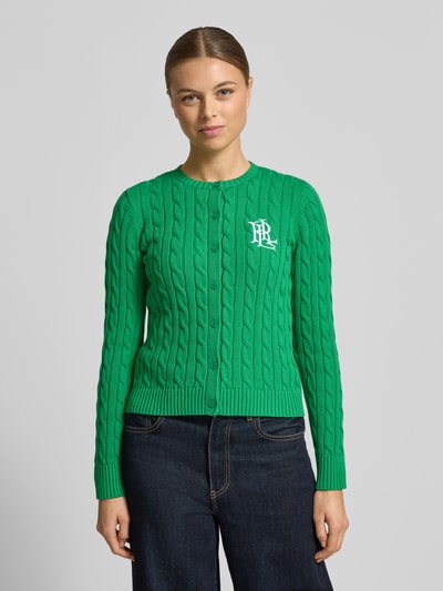 Frauenmodel trägt grüne Strickjacke mit Zopfmuster und Label-Stitching Modell 'RALHAN' von Lauren Ralph Lauren, Slim Fit, Vorderansicht Oberkörper.