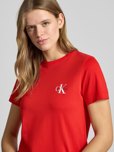 Modelka nosi T-Shirt Set mit Logo und Rundhalsausschnitt von Calvin Klein Jeans, czerwona bawełna, krój regular fit, logo z przodu, półzbliżenie tułowia