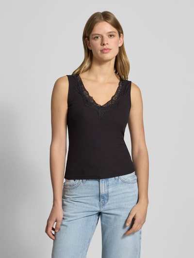Kobiece modelka nosi Trägertop mit V-Ausschnitt und Spitze od Gina Tricot, mieszanka bawełny, dopasowany krój, efekt prążkowania, czarny, dekolt w serek z koronką, długość tyłu 53 cm przy rozmiarze S, całe ciało widoczne z przodu.