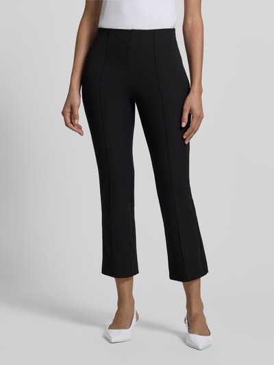 Frauenmodel trägt Flared Stoffhose mit Nahtreißverschluss von Jake*s Collection, schwarze Stoffstruktur, Eingrifftaschen, Nahaufnahme Oberkörper.
