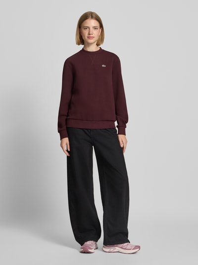 Modelka nosi Relaxed Fit Sweatshirt aus Baumwoll-Mix od Lacoste, ciemny bordowy kolor, gładka faktura, damska bluza, Ganzkörperansicht von vorne