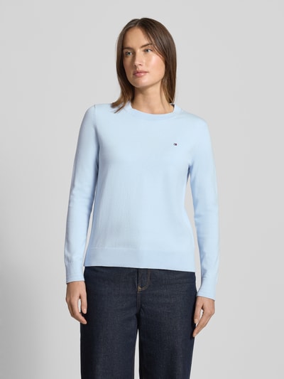 Kobiece model prezentuje Regular Fit Strickpullover aus Baumwoll-Mix od Tommy Hilfiger, jasnoniebieski, gładki, długie rękawy, dekolt crew neck, dzianina prążkowana, logo, bawełniany miks, widok na cały przód.