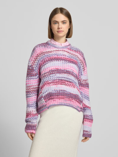 Frauenmodel trägt Regular Fit Pullover in Strick-Optik Modell 'Simone' von JJXX, bunte Streifen in Rosa, Lila, Weiß, Rundhalsausschnitt, Ganzkörperansicht von vorne.