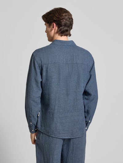Männermodel trägt Slim Fit Freizeithemd aus Leinen-Baumwoll-Mix Modell 'NELSON' von Redefined Rebel, dunkelblau, strukturierte Oberfläche, Rückenlänge 50 cm, Schulterbreite 49 cm, Ärmellänge 72 cm, mit Kentkragen, Brusttasche und Label-Detail, Ganzkörperansicht Rückansicht.