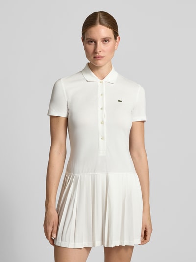Vrouwenmodel draagt wit regular fit vrijetijdsjurk van katoenmix, Regular Fit Vrijetijdsjurk uit katoenmix van Lacoste, Nahaufnahme Oberkörper. Dames vrijetijdsjurk von Lacoste.